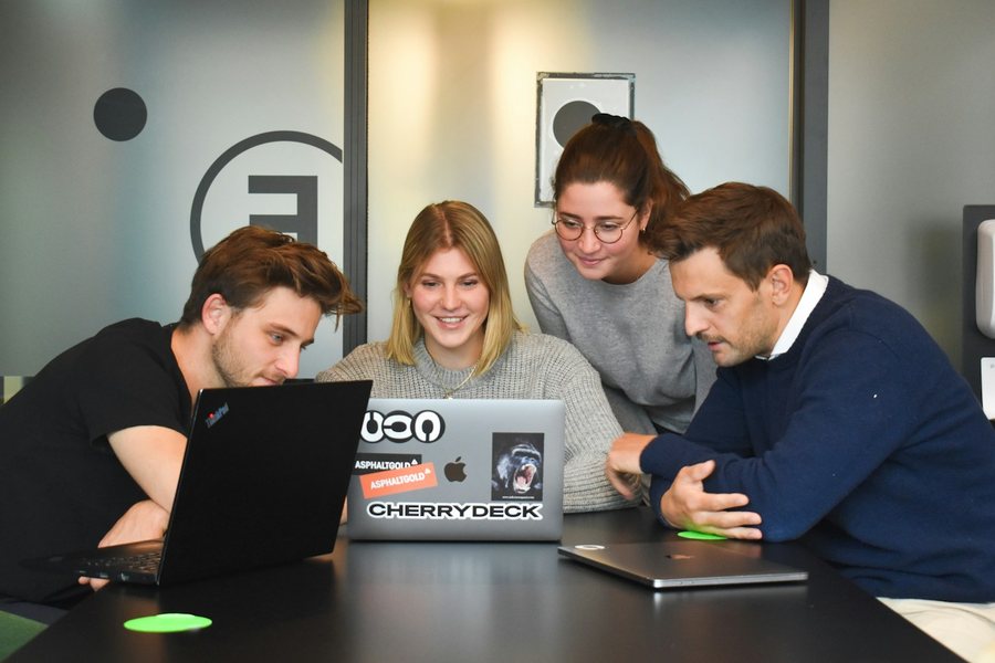 Team collaborating around a laptop