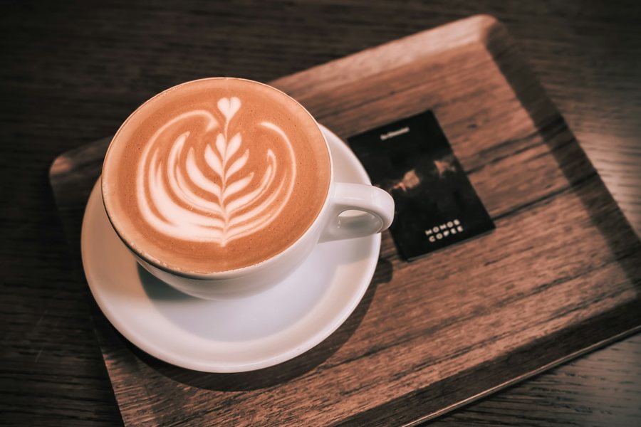 Cappuccino on a tray with a loyalty card