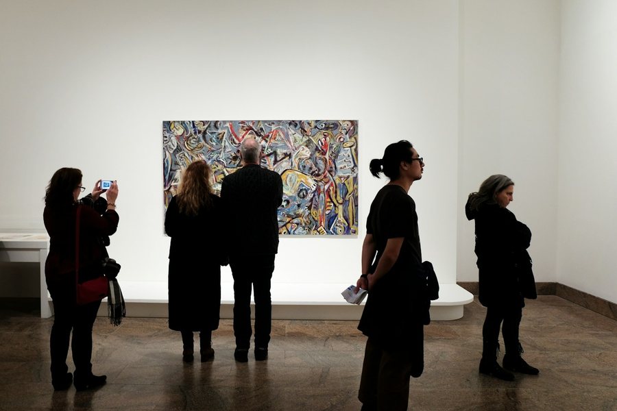 Visitors viewing a painting in a gallery